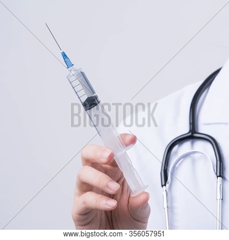 Doctor Holding Syringe With Face Mask, Concept Of Young Female Physican Injects Coronavirus, Covid-1