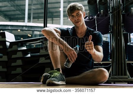 Caucasian Young Handsome Man Showing Thumbs Up And Drinking Water While Resting After Exercise Worko