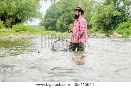 Summertime. Hobby And Sport Activity. Pothunter. Mature Man Fly Fishing. Man Catching Fish. Bearded 