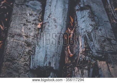 Old Wooden Decayed And Ramshackle Railway Sleepers Stacked Up On Side Of Railway Line