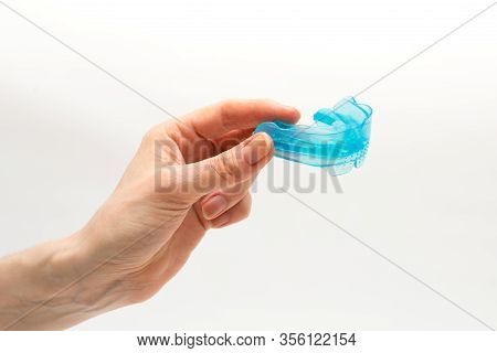 Myofunctional Trainer For Correction Of Bite And Alignment Of Teeth In The Hand Of Woman On White Ba