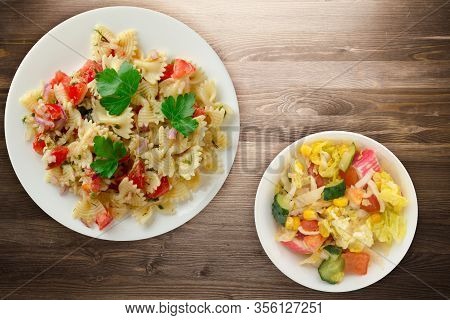 Pasta On A White Plate. Pasta Tomatoes, Onions, Cabbage On A Brown Wooden Background. Pasta With Veg