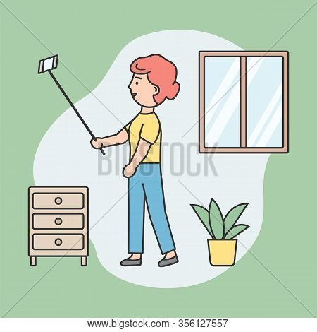 Concept Of Making Selfie. Young Attractive Woman Is Making Selfie By Smartphone On Stick At Home. Yo
