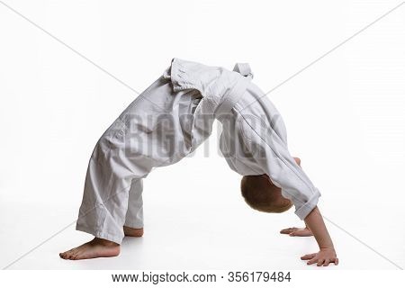 Boy Athlete Makes A Bridge At The Warm-up Of The Judo Section