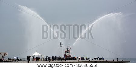 Trieste Italy 05 19 2019: Deneb Tug Boat In Trieste Italy Giving Farewell Salute With Fire Hoses Wit