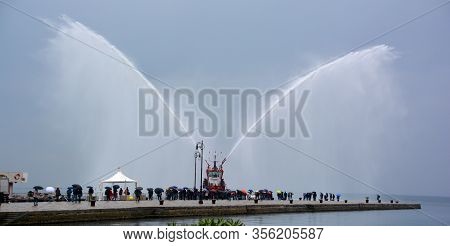 Trieste Italy 05 19 2019: Deneb Tug Boat In Trieste Italy Giving Farewell Salute With Fire Hoses Wit