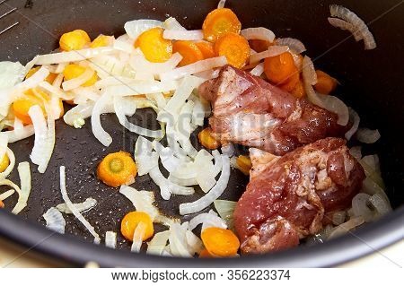 Cooking. Roasting Pieces Of Meat With Carrots Or Onions In A Multicooker Bowl