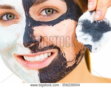 Woman With Clay Carbo Black Mask On One Half Face And White Mud On Second Half. Girl Removing Cosmet