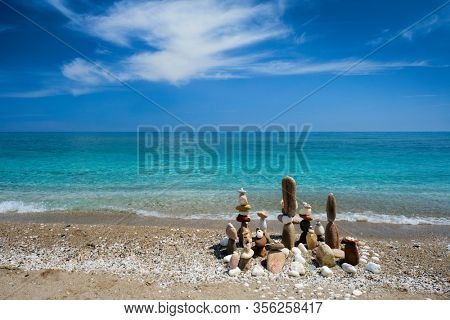Concept of balance and harmony. Stones pebbles stacks on the beach coast of the blue sea in the nature. Meditative art of stone stacking.