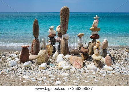 Concept of balance and harmony. Stones pebbles stacks on the beach coast of the blue sea in the nature. Meditative art of stone stacking.