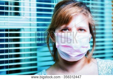 Coronavirus Quarantine. The Woman In An Antiviral Mask Is Indoors By The Window. House Arrest.