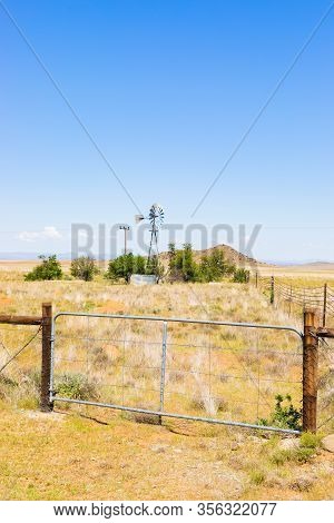 Windmill On A Farm In Rural Grassland Area Of South Africa