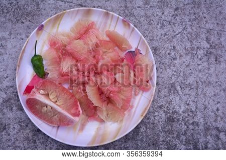 Pomelo (robab Tenga) Citrus Fruit Inner Parts With Ghost Chili Pepper (bhut Jolokia) In A Plastic Pl