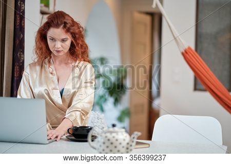 Nice beautiful lady work at the notebook sit  at home - check on oline shops for cyber monday sales - technology woman concept for alternative office freelance. virus epidemic allert