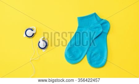 Blue Sports Socks And Blue Vintage Headphones On A Yellow Background. The Concept Of Music And Sport