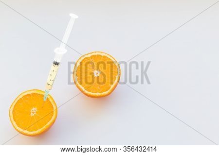 High Dose Vitamin C, Ampule For Injection. Syringe In Fresh Juicy Orange Fruit Slides. Concept Of Vi
