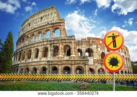 Prohibition signs with model of Coronavirus molecule and crossed out man on a warning fencing ribbon on a background of Colosseum in Rome, Italy. Coronavirus, Covid 19 pandemic, Quarantine concept.