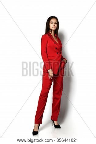 Self-confident Sexy Brunette Woman In Stylish Red Office Pantsuit And High-heeled Shoes Is Posing Wi