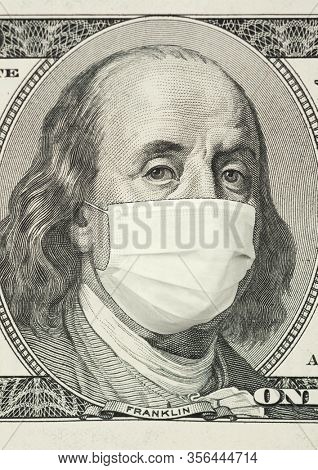 Portrait of Franklin on 100 dollar banknote with medical mask. The concept of coronavrius epidemic and the financial crisis caused by this collapse