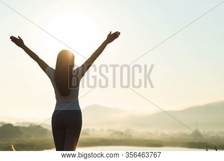 Silhouette Of Happy Woman Spreading Arms And Watching The Mountain. Travel Lifestyle Success Concept