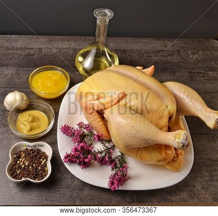 Appetizing Chicken In A White Plate, Honey, Mustard, Pepper And Oil On A Dark Table