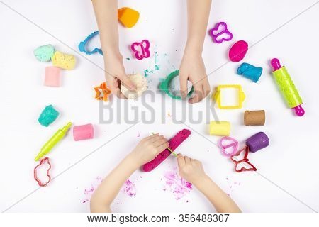 Little Girls Hands Playing With Colorful Modeling Clay On White Background. Educational Game With Cl