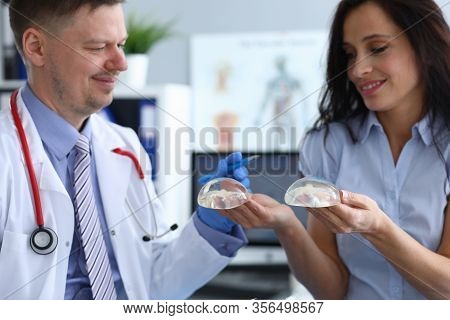 Close-up Of Smiling Lady Holding Implants. Lovely Female Person At Consultation With Professional Do