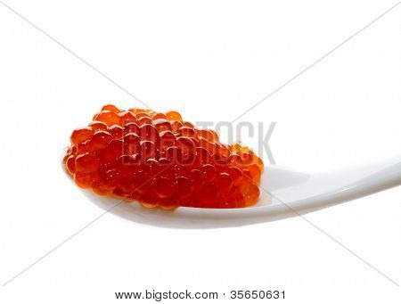 Red caviar on the spoon, on a white background
