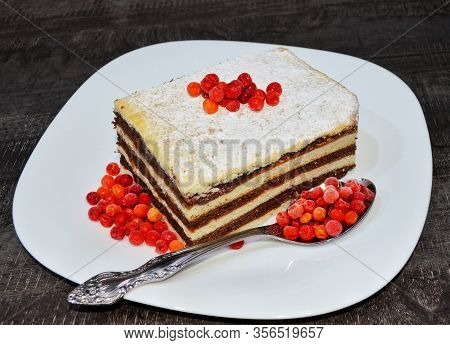 mouth-watering tea cake in a white plate with berries on a dark table