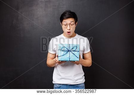 Celebration, Holidays And Lifestyle Concept. Surprised And Excited, Amazed Asian Guy Receive Gift Bo