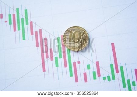 Ten Rouble Coin On Currency Graph. Exchange Rate Chart. Ruble Depreciation. Exchange Rate Of Rouble 