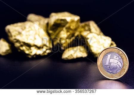 One Real Coin, With Gold Nuggets. Concept Of Devaluation Of The Brazilian Currency Or Stock Exchange