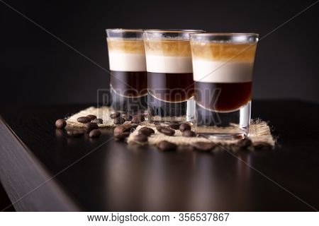 Three Shots Of B-52 Cocktail Placed On A Bar Counter