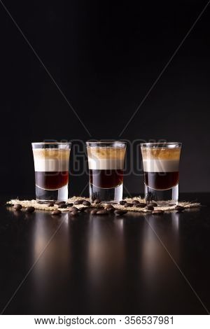 Three Shots Of B-52 Cocktail Placed On A Bar Counter With Copy Space