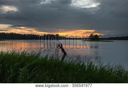 Grass And Lake During Sunset.