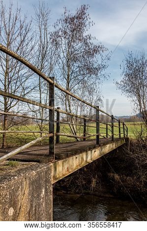 Little Iron Bridge Across The Little River And A Green Meadow