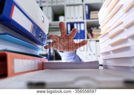 Among Folders And Documents Mans Hand Seeks Help. Multitasking Absorbs Energy And Time. Habit Puttin