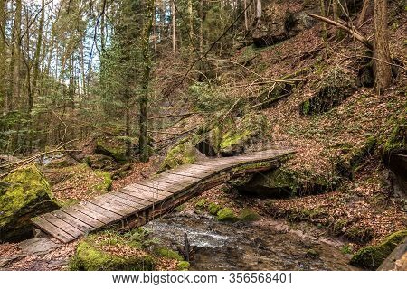 Little Bridge Across The Creek Down The Canyon In The Middle Of The Green Forest