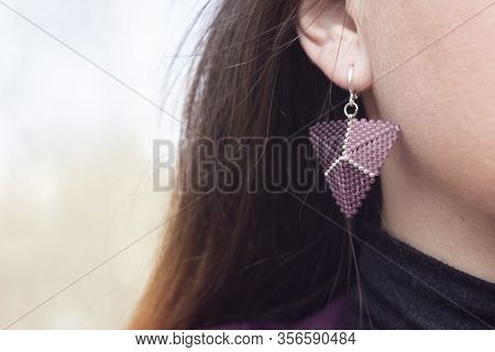 Young Woman With Bead Earring In Ear. Purple Ear Decoration, Background