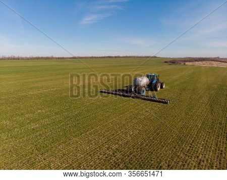 Tractor Applying Liquid Mineral Fertilizers To The Soil On Winter Wheat