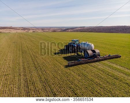 Tractor Applying Liquid Mineral Fertilizers To The Soil On Winter Wheat