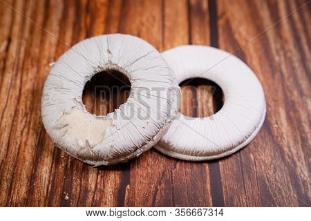 Need A Replacement Embouchures On Old White Earbud. Repair Accessories.wooden Background
