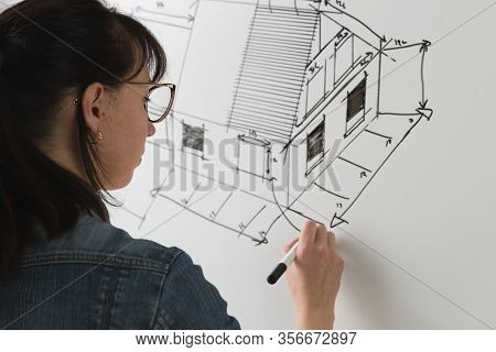 Close-up Of A Young Female Architect Drawing A Sketch For A New Famaly Home Project. Concept Of Work