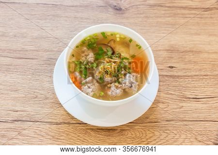 Boiled Rice With Pork In A White Cup Placed On A Wooden Table