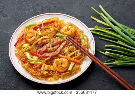 Singapore Mei Fun In White Plate On Dark Slate Background. Singapore Noodles Is Chinese Cuisine Dish