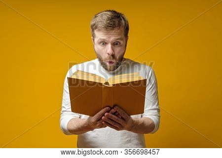Man In A Yellow Scarf, Spellbound, Reads An Interesting Book And Is Surprised At What Is Written. Ed