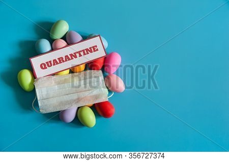 The Concept Of Quarantine At Easter Time. A Medical Mask With A Quarantine Warning Sign And Multicol