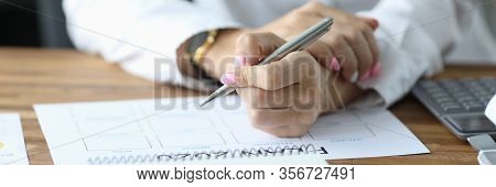Close-up View Of Womans Hands Filling Paper With Months. Person Sitting In Office With Silver Pen An