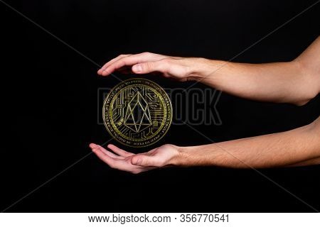 The Symbol Of The New Popular Cryptocurrency Eosio With The Image Of Hands On Dark Background