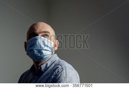 Caucasian Man Wearing Protective Standard Ffp1 Antiviral Face Mask Looking Up Over Blank Home Wall B